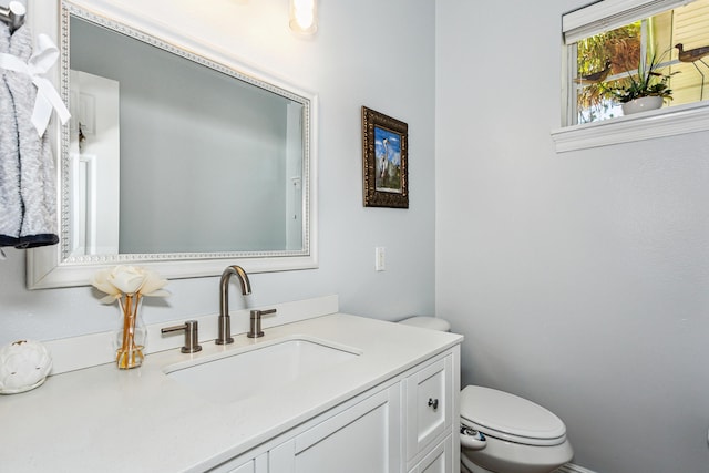 half bathroom featuring vanity and toilet