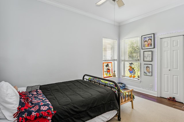 bedroom featuring baseboards, ceiling fan, wood finished floors, crown molding, and a closet