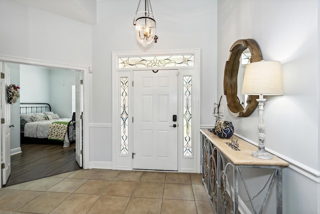 entrance foyer featuring a chandelier, a towering ceiling, and light tile patterned floors