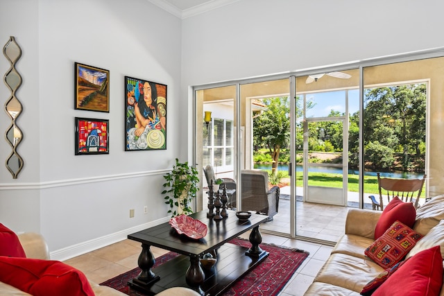 tiled living area with plenty of natural light, a water view, baseboards, and crown molding