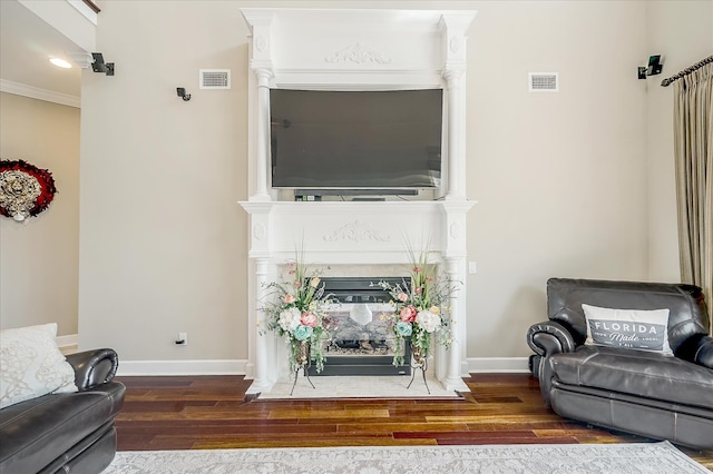 living room with dark hardwood / wood-style flooring and crown molding