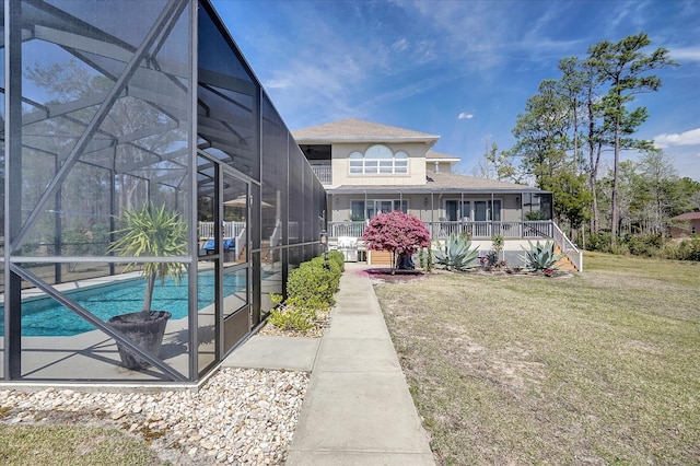 back of house featuring glass enclosure and a lawn