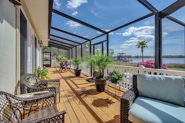 sunroom featuring lofted ceiling and a water view