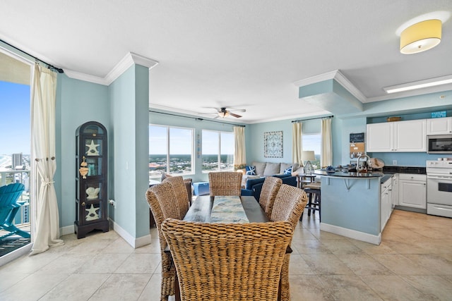 dining space featuring ceiling fan, light tile patterned floors, and ornamental molding