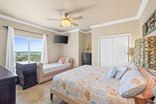 tiled bedroom with a closet, ceiling fan, and crown molding