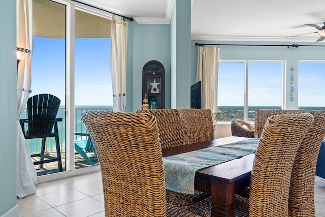 dining area featuring ceiling fan, light tile patterned flooring, a water view, and crown molding