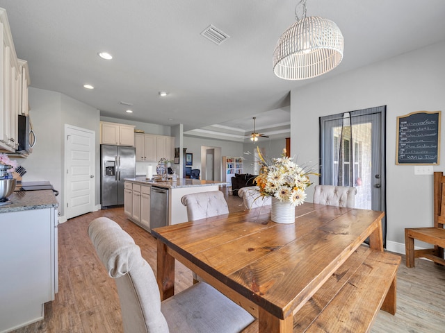 dining area featuring ceiling fan, light hardwood / wood-style flooring, and sink