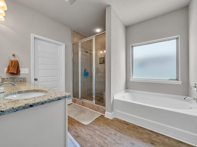 bathroom featuring wood-type flooring, vanity, and separate shower and tub