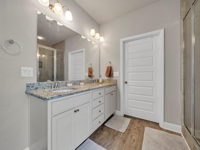 bathroom with vanity, hardwood / wood-style flooring, and a shower with shower door