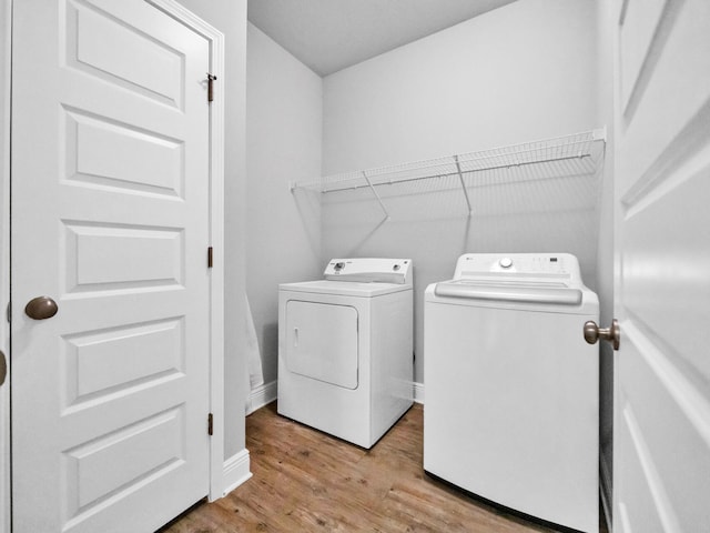 laundry room with light wood-type flooring and washer and clothes dryer