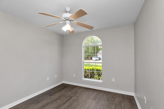 spare room featuring ceiling fan, dark hardwood / wood-style floors, and a textured ceiling