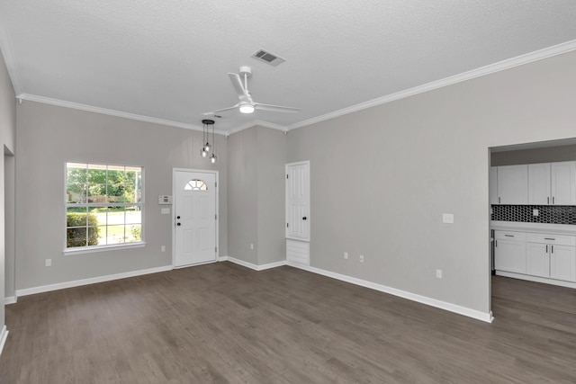 unfurnished living room with ceiling fan, crown molding, dark hardwood / wood-style floors, and a textured ceiling