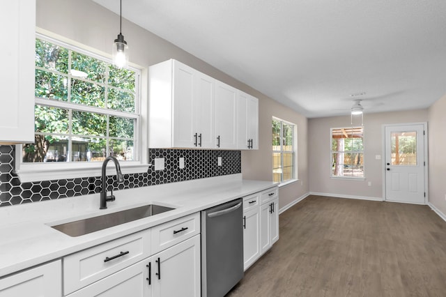 kitchen with dishwasher, white cabinetry, sink, and decorative light fixtures