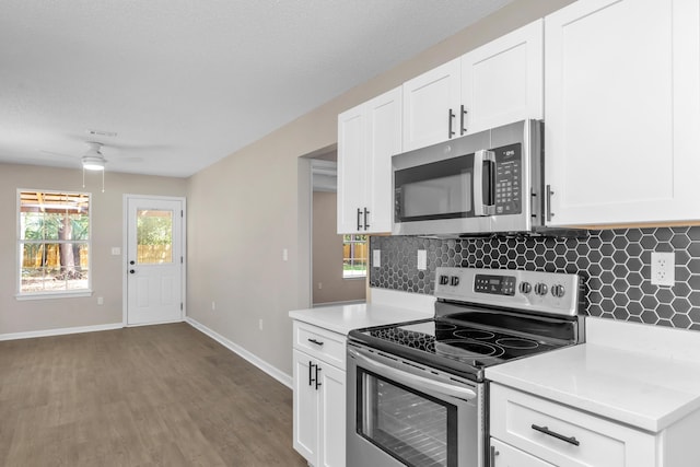 kitchen featuring decorative backsplash, white cabinetry, ceiling fan, and appliances with stainless steel finishes