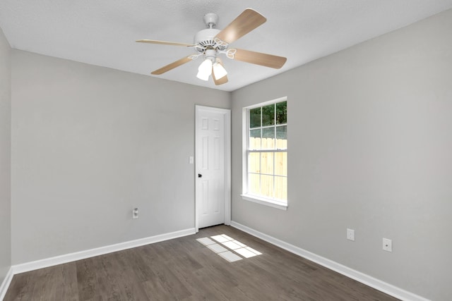 empty room with ceiling fan and dark wood-type flooring