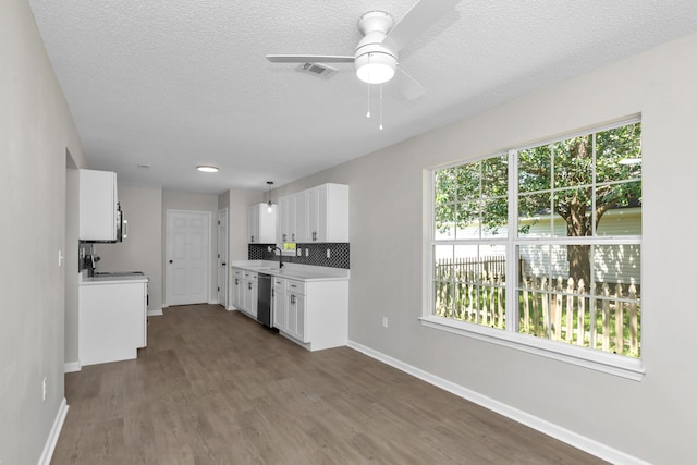 kitchen with stove, stainless steel dishwasher, decorative backsplash, ceiling fan, and white cabinetry