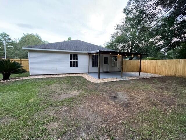 rear view of property featuring a lawn and a patio area