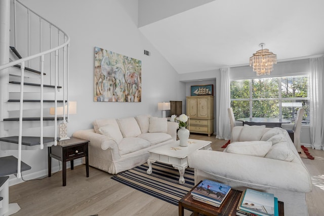 living room featuring light wood-type flooring, high vaulted ceiling, and a notable chandelier