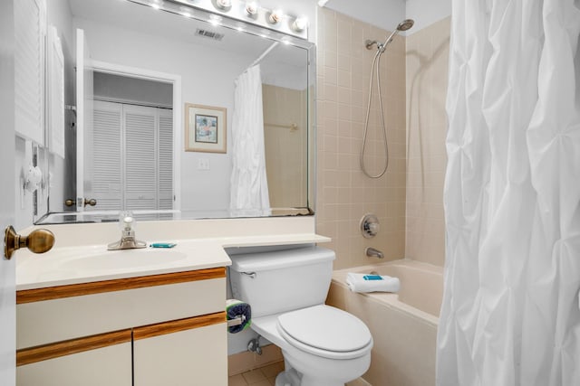 full bathroom featuring shower / bath combo with shower curtain, tile patterned floors, toilet, and vanity