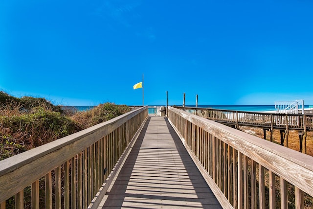 surrounding community featuring a water view and a beach view