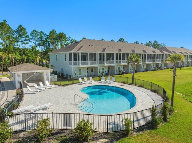 view of pool featuring an outbuilding, a patio, and a lawn