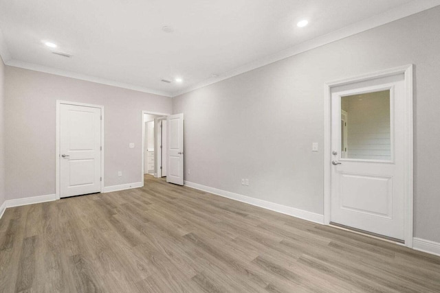 spare room featuring ornamental molding and light wood-type flooring