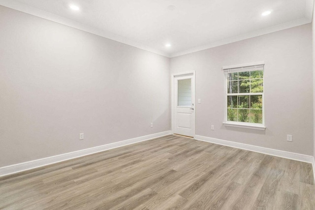 empty room featuring crown molding and light wood-type flooring