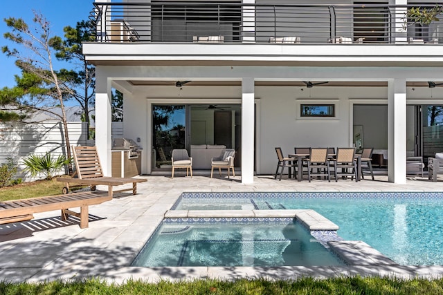 back of property featuring a swimming pool with hot tub, a balcony, and ceiling fan