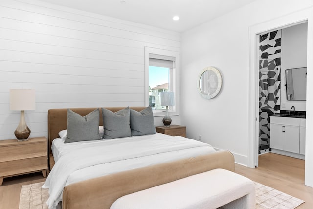 bedroom featuring light hardwood / wood-style flooring and sink