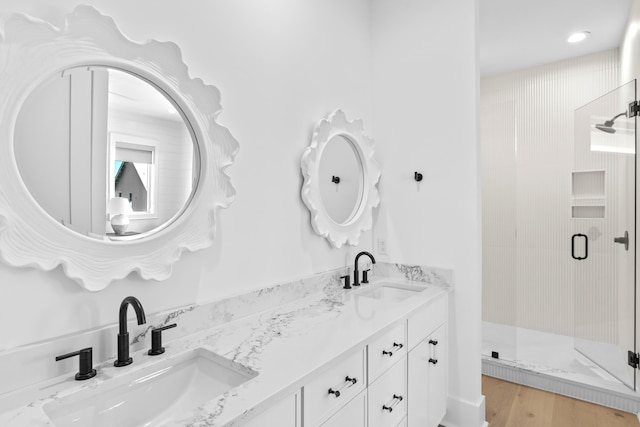 bathroom with hardwood / wood-style flooring, vanity, and walk in shower