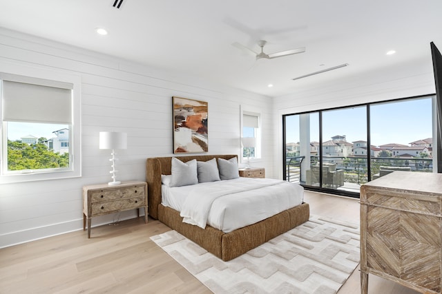 bedroom featuring access to outside, multiple windows, ceiling fan, and light wood-type flooring