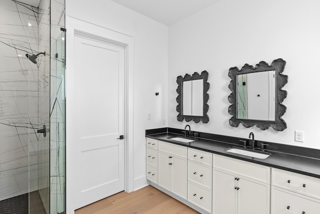 bathroom with wood-type flooring, vanity, and walk in shower