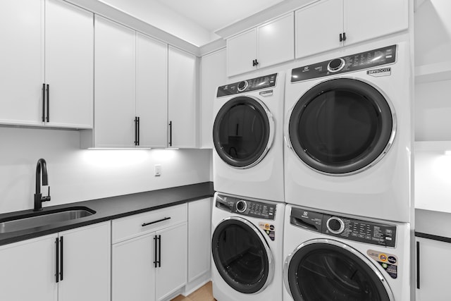 laundry room with washer and clothes dryer, stacked washer and dryer, cabinets, and sink