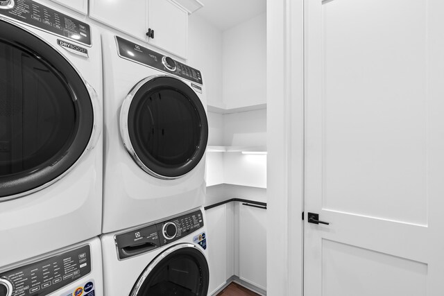 5050 W County Highway 30a, Santa Rosa Beach, FL 32459 - washroom with stacked washer / dryer and cabinet space