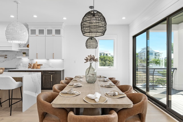 dining room with light hardwood / wood-style flooring and an inviting chandelier