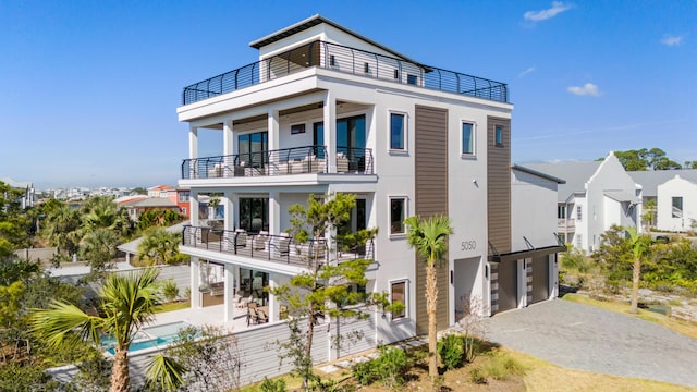 5050 W County Highway 30a, Santa Rosa Beach, FL 32459 - view of front of house featuring a balcony, driveway, an outdoor pool, and a garage