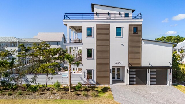 5050 W County Highway 30a, Santa Rosa Beach, FL 32459 - view of front of house with an attached garage, french doors, driveway, a balcony, and stucco siding