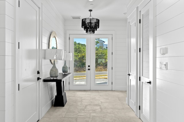 doorway with french doors and a notable chandelier