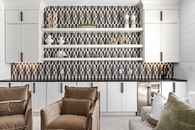 bar with wine cooler, sink, and white cabinets