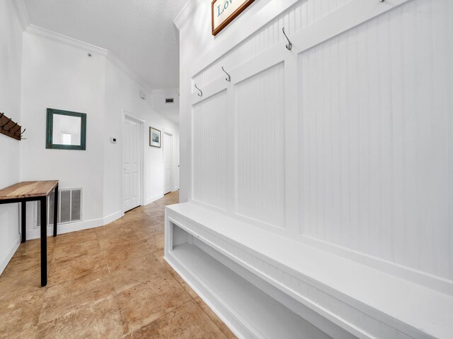 mudroom with ornamental molding and light tile patterned flooring