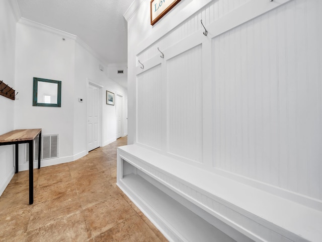 mudroom with crown molding and a textured ceiling