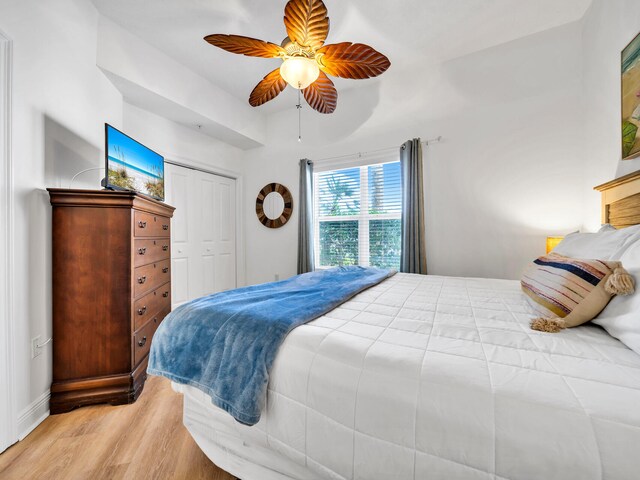 bedroom with light hardwood / wood-style floors, a closet, and ceiling fan