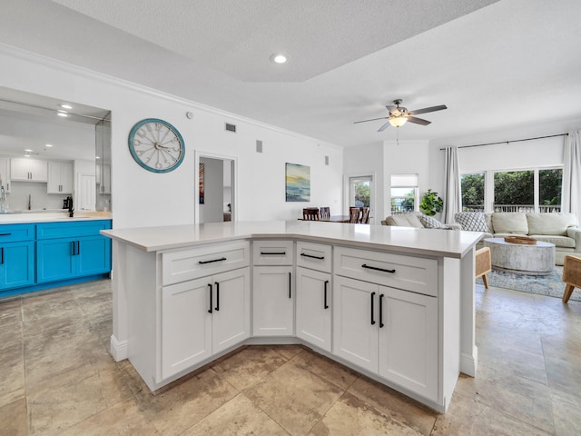 kitchen with ceiling fan, a textured ceiling, and white cabinets