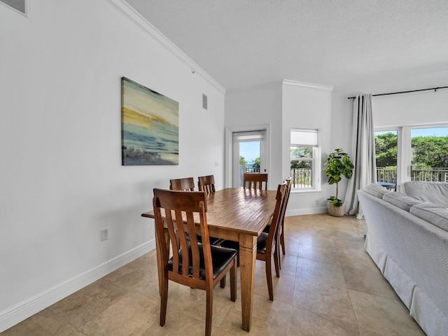 dining room featuring ornamental molding and a textured ceiling