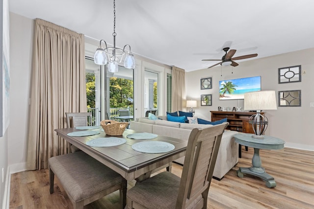 dining area featuring ceiling fan with notable chandelier and light hardwood / wood-style floors