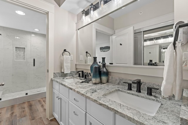 bathroom with hardwood / wood-style flooring, walk in shower, and vanity