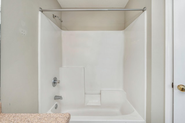 bathroom with shower / bath combination and a textured ceiling