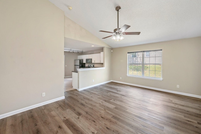 unfurnished living room featuring a textured ceiling, ceiling fan, lofted ceiling, and hardwood / wood-style flooring