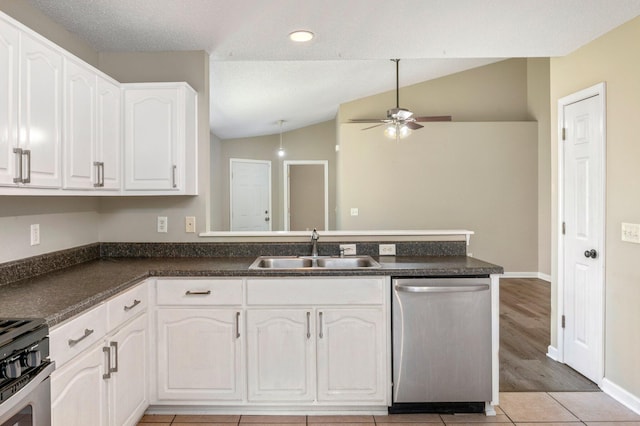 kitchen with kitchen peninsula, stainless steel appliances, sink, white cabinetry, and lofted ceiling