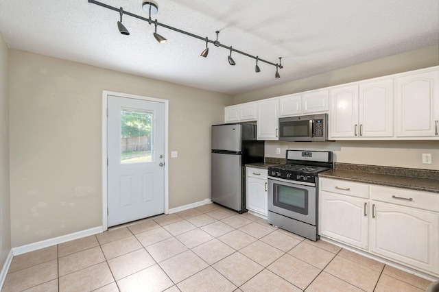 kitchen featuring appliances with stainless steel finishes, a textured ceiling, track lighting, and white cabinetry